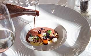 Angerichtete Speise auf Teller mit einem Glas Wein